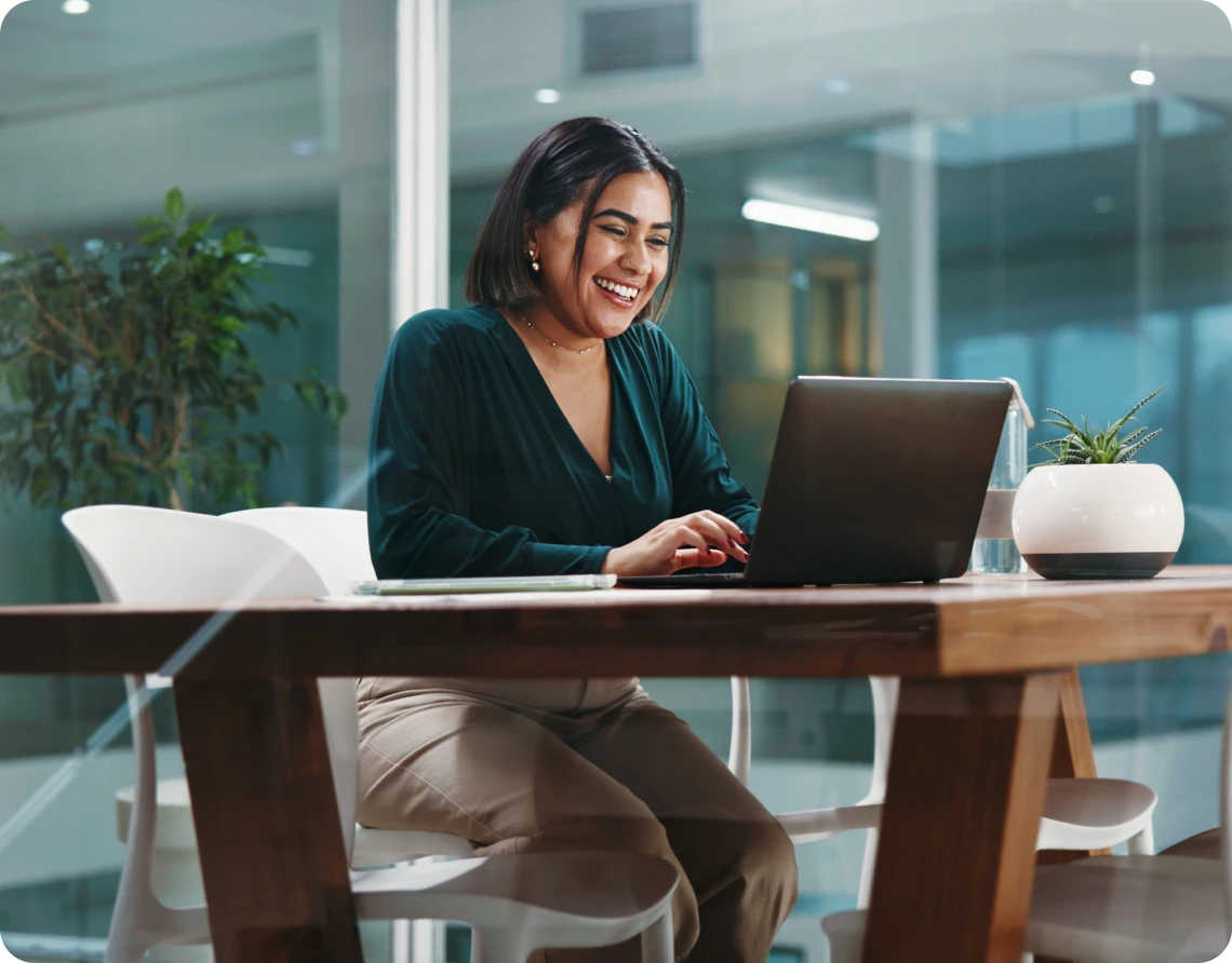 Woman smiling at laptop in office