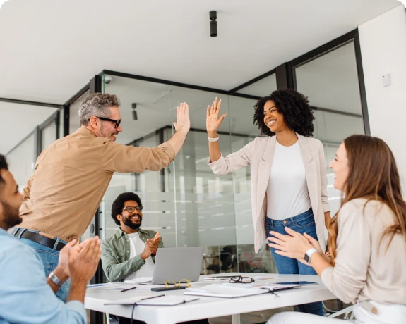 Coworkers high-fiving during a meeting